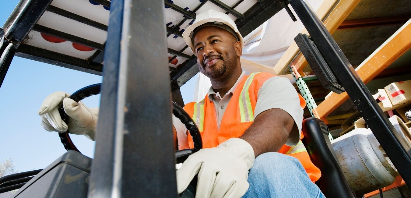 Middle aged man operating construction equipment wearing safety gear